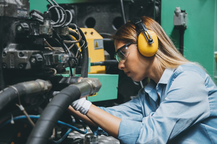 kobieta naprawia robota przemysłowego